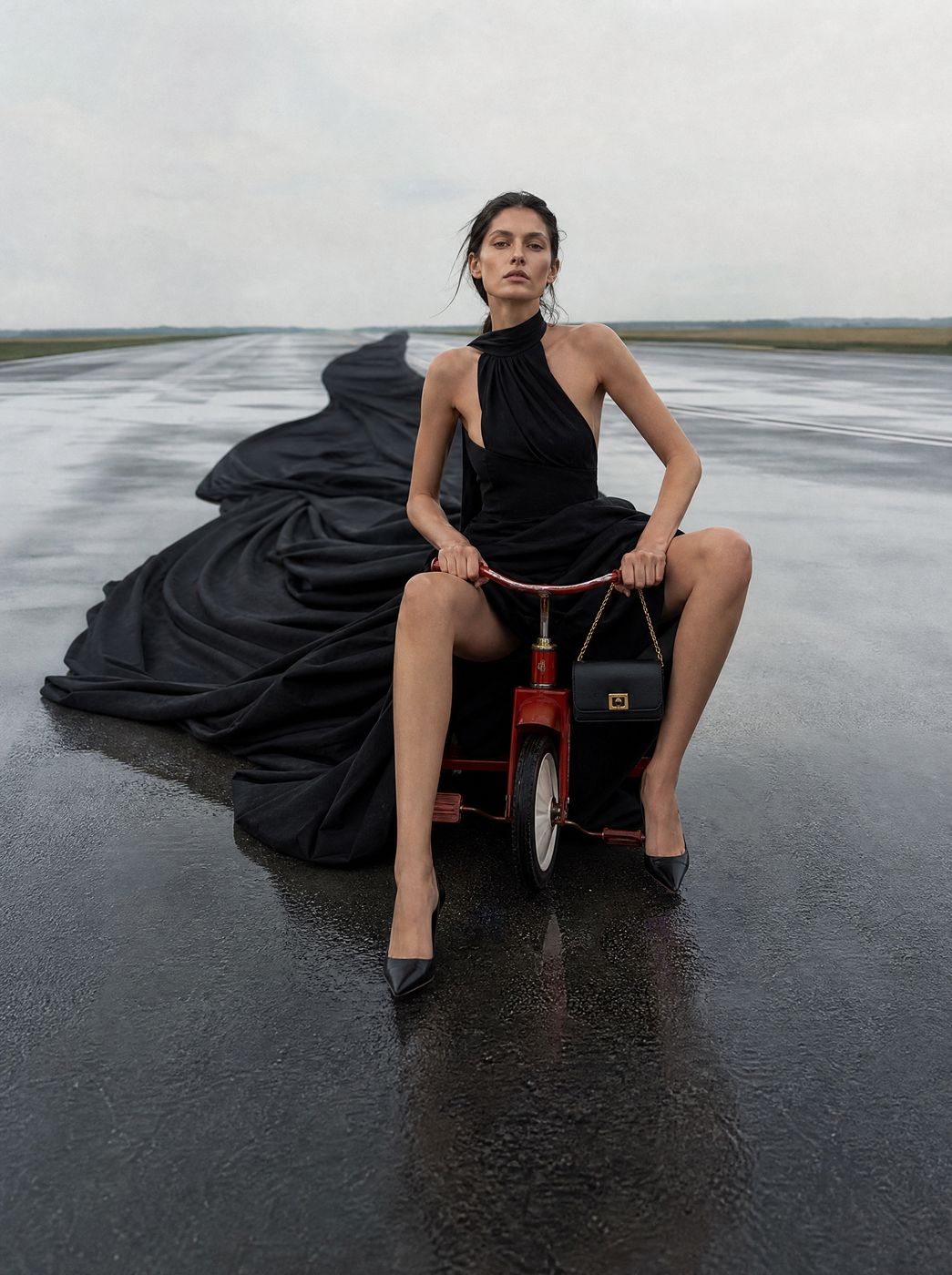 Woman in black dress on a red tricycle